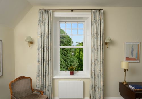 elegant, floor-length custom window curtains feature a traditional double pinch pleat heading and a soft sage and cream botanical pattern at Park Hotel Kenmare.