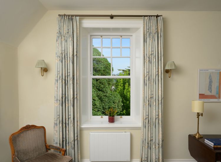 elegant, floor-length custom window curtains feature a traditional double pinch pleat heading and a soft sage and cream botanical pattern at Park Hotel Kenmare.