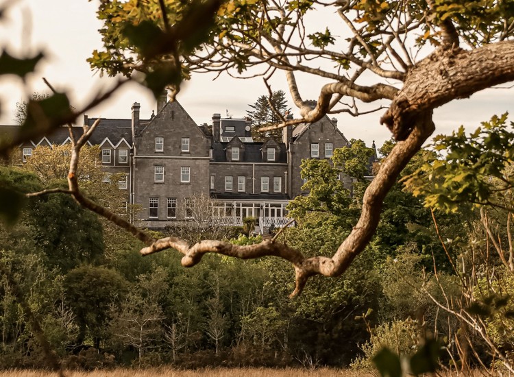 Park Hotel Kenmare in County Kerry, Ireland, framed by tree branches.